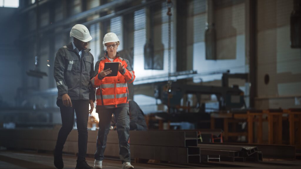 Two industrial workers in a manufacturing plant.