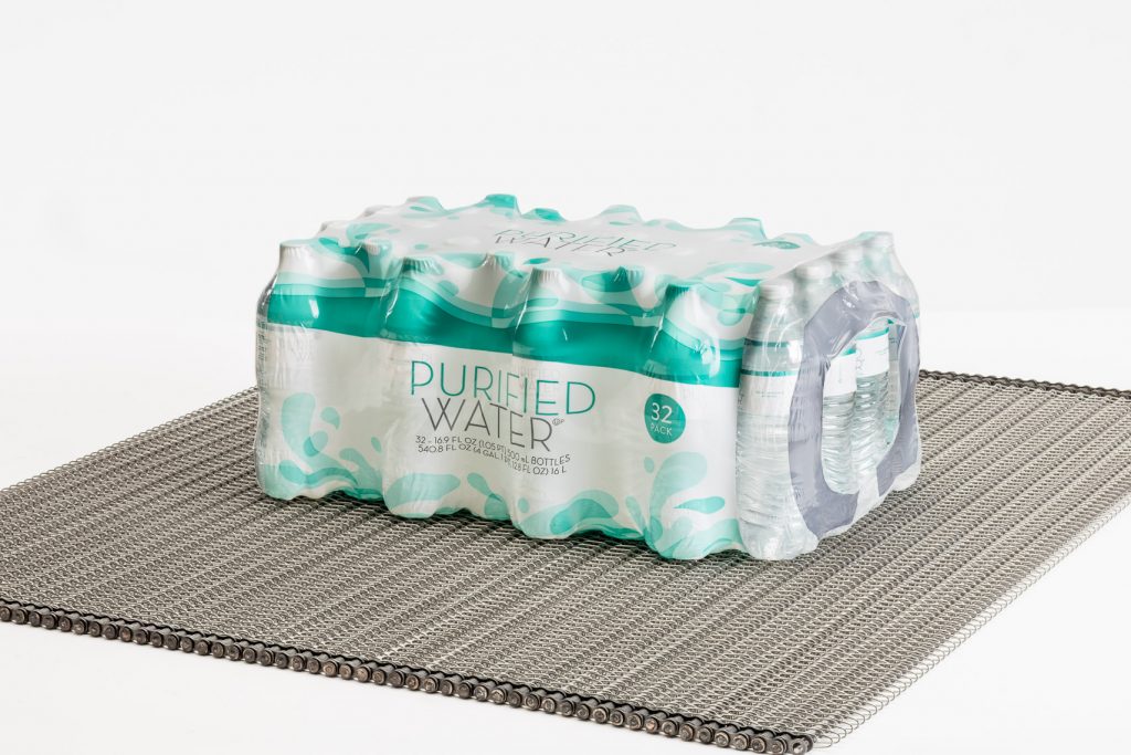 A chain driven conveyor belt transporting a case of spring water.